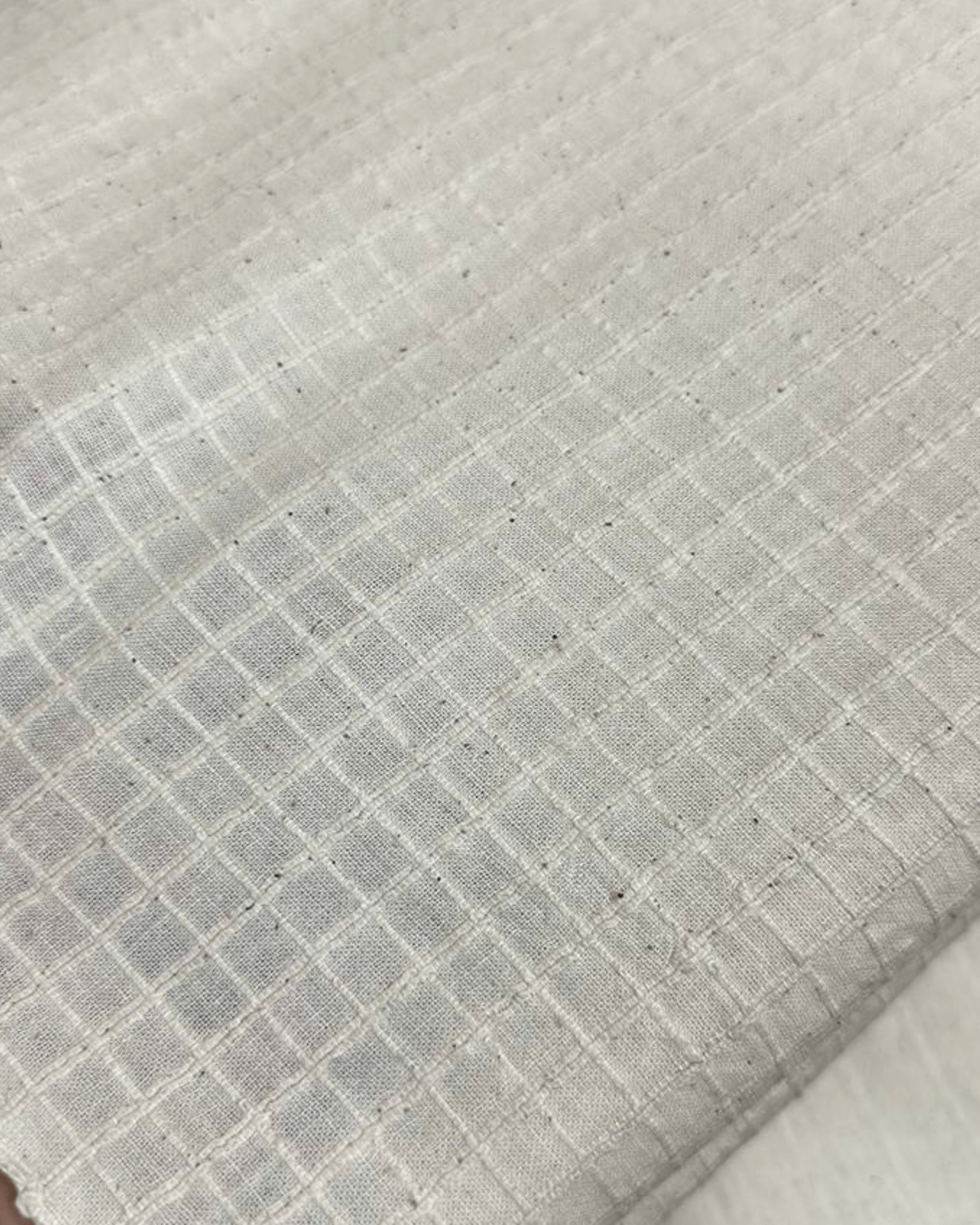 Close-up of handwoven 33 counts Indigenous Kora fabric with check weave pattern in natural tones.