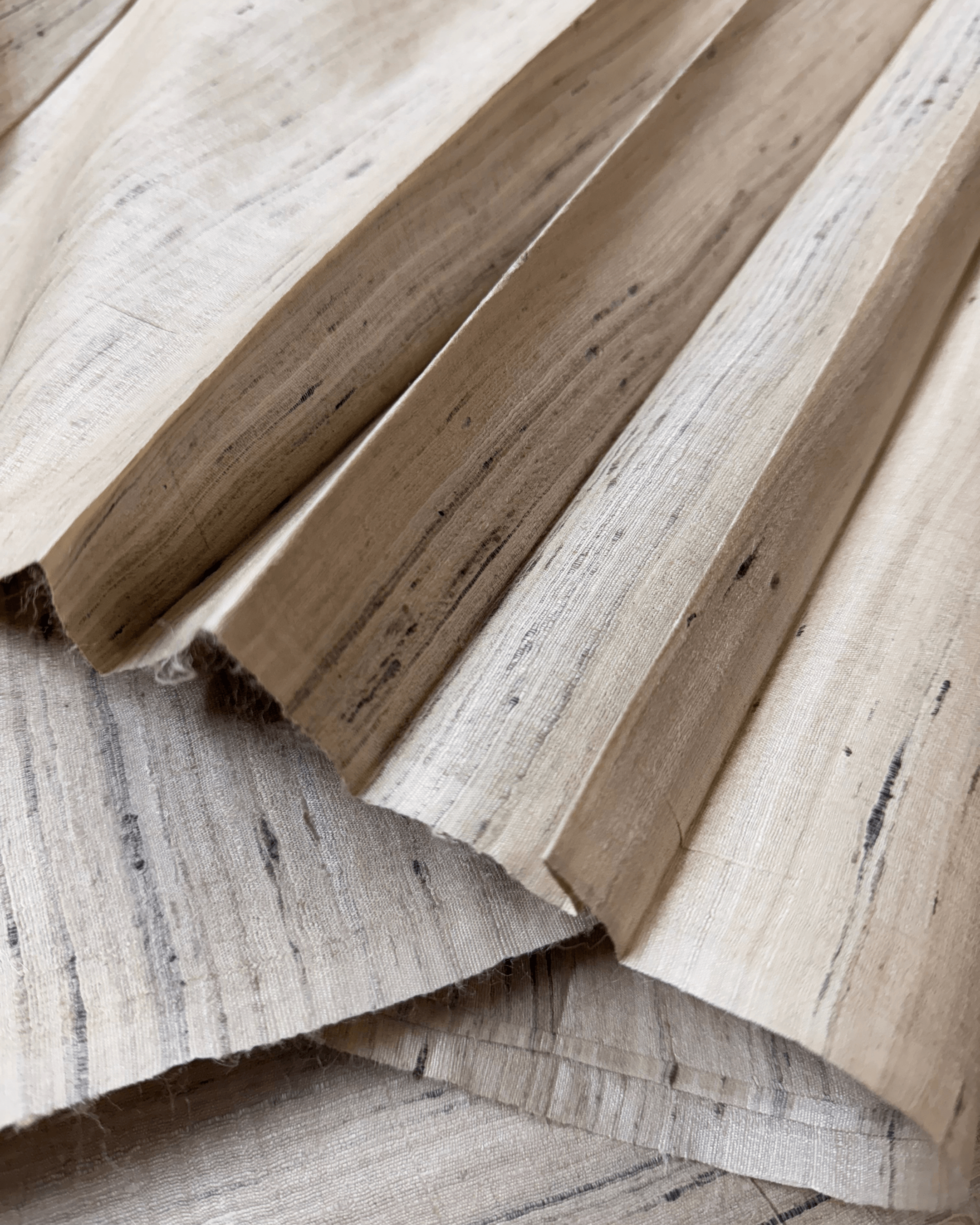 Close-up of hand spun Tassar silk fabric in raw color, showcasing its soft texture and natural beauty from West Bengal, India.